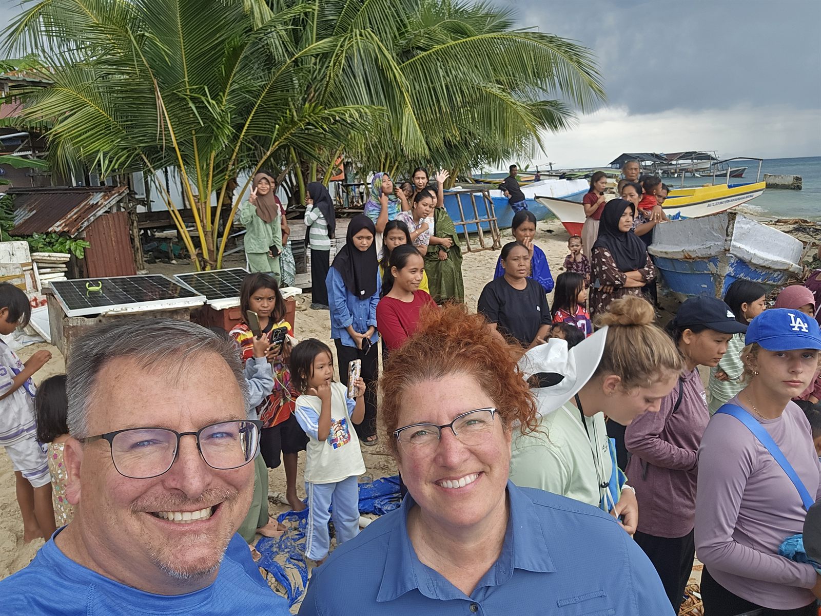 Dennis and Christine Cole with a community on a beach in Indonesia